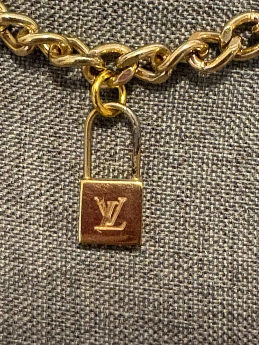 Authentic Louis Vuitton Lock Charm and other unbranded charms on bag chain